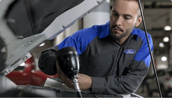 Certified Ford Service Technician installing OEM Parts on a Ford vehicle