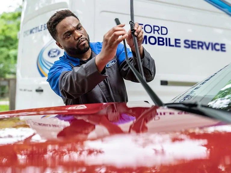 Exterior shot of Cloninger Ford Technician repairing window wipers